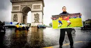 National Soccer Hall of Famer Esse Baharmast poses with an image of a famous World Cup call that he made as a referee.